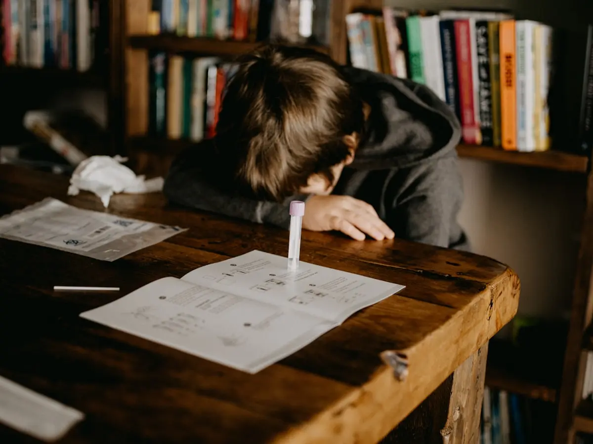 Lycéen concentré sur ses révisions du bac avec des livres ouverts sur une table en bois