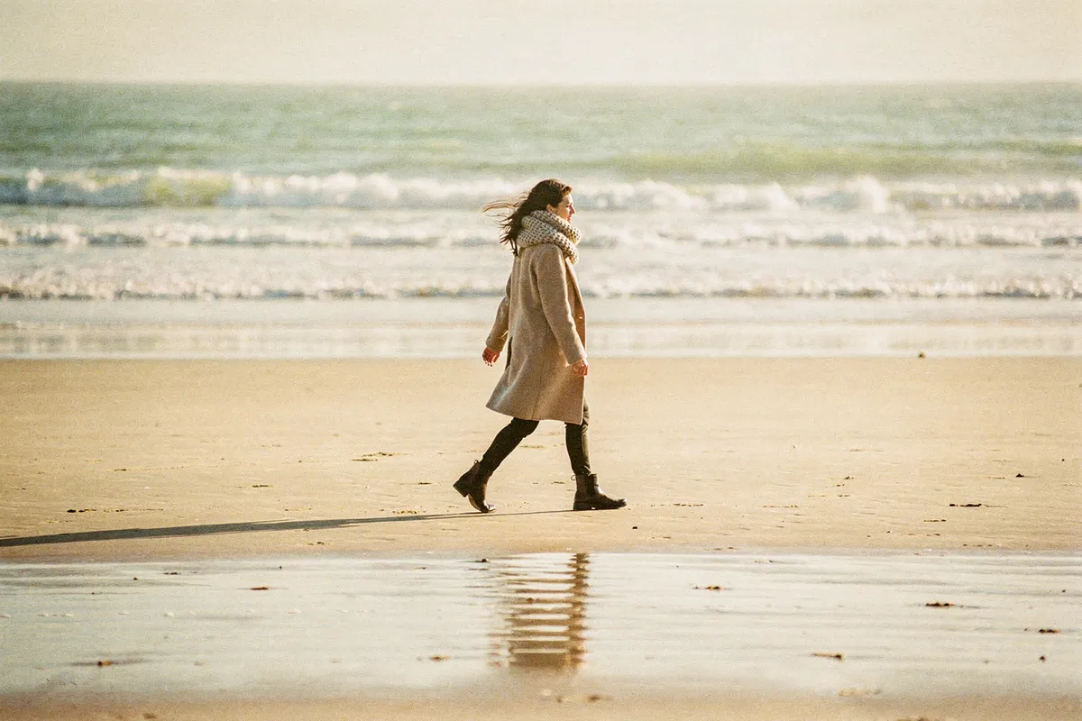 Marche rapide sur une plage vendéenne déserte en fin d'hiver, sous un soleil bas