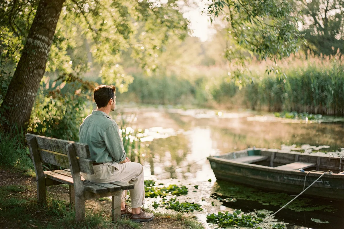 Personne assise en silence sur un banc au bord d'une conche du marais poitevin